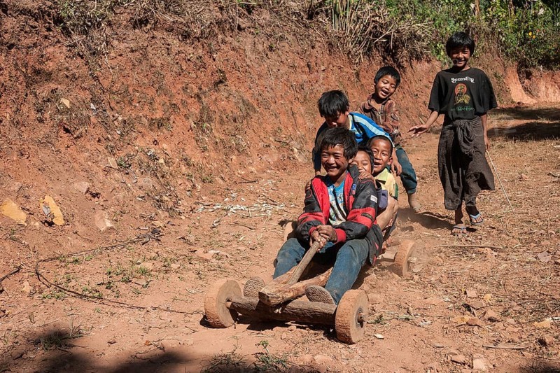 Children from Palaung tribe ride homemade vehicle in Kalaw
