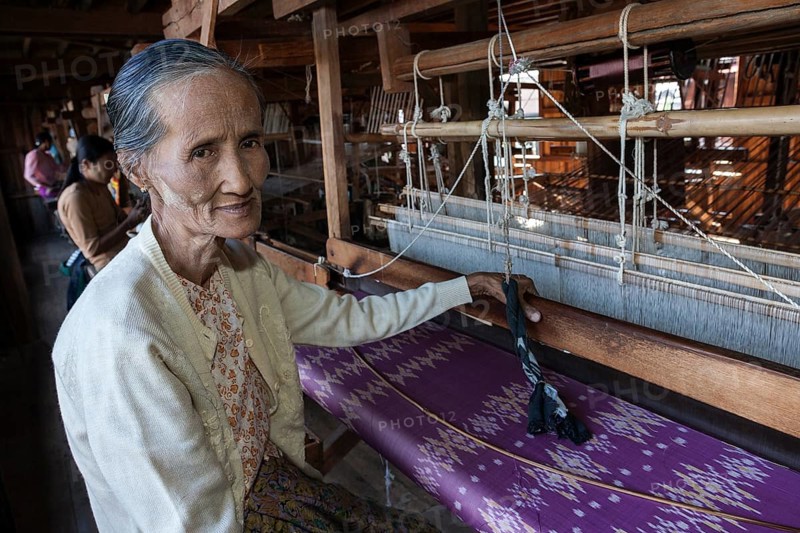 Old local woman weaving fabric from lotus flower silk