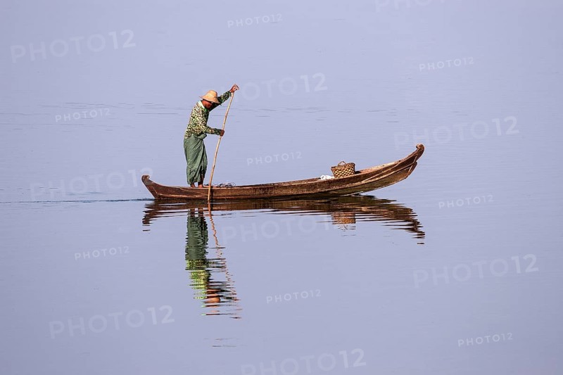 Local man on a wooden boat on the Taungthaman lake