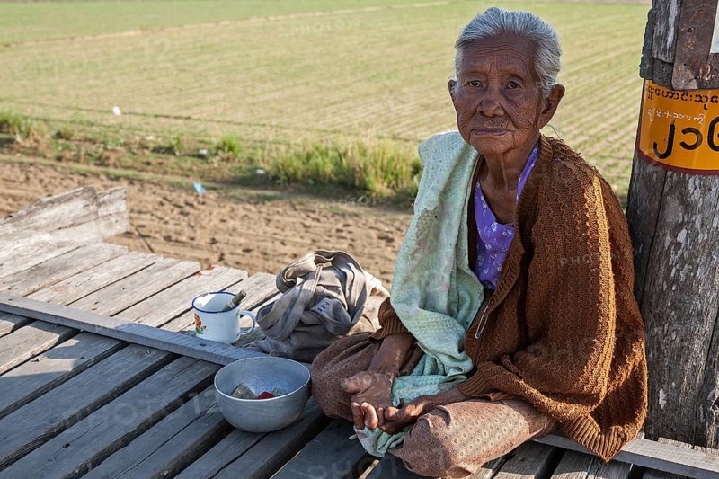Native leper woman sitting on the U Bein Bridge