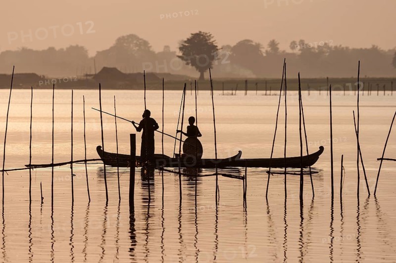 Two people standing in a dugout canoe