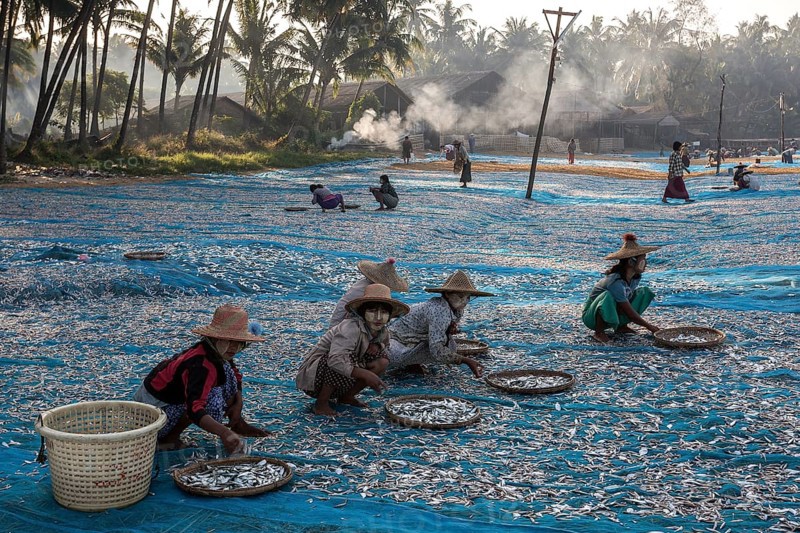 Local women wearing straw hats and Thanaka paste on their faces