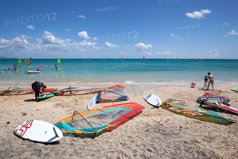 Windsurfing boards and sails lying on the beach