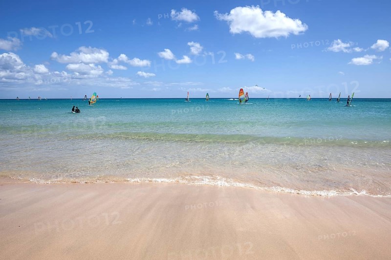 Windsurfers in the turquoise waters off the Playa Risco del Paso beach