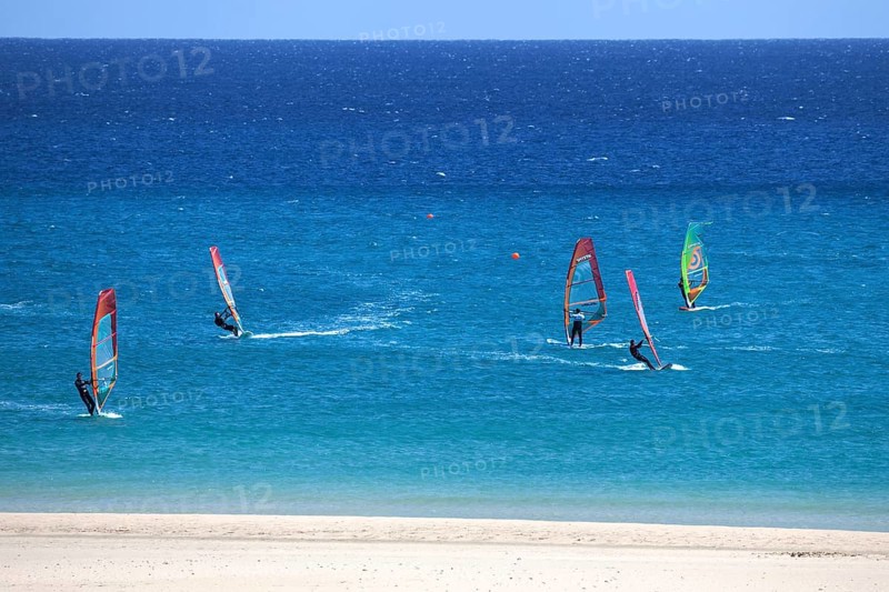 Windsurfers in the turquoise waters off the Playa Risco del Paso beach