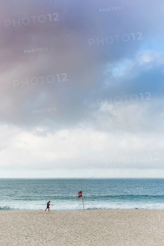 Man running in the early morning on Sao Conrado beach