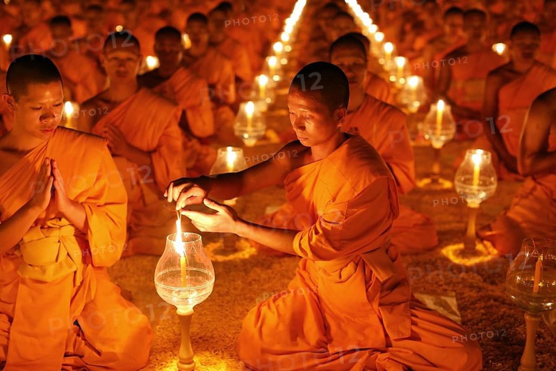 Monk lights candle