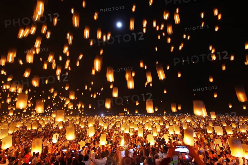 People letting sky lanterns rise