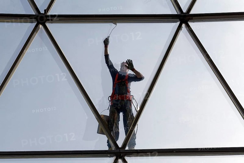 Painter painting the steel tube construction of a glass dome