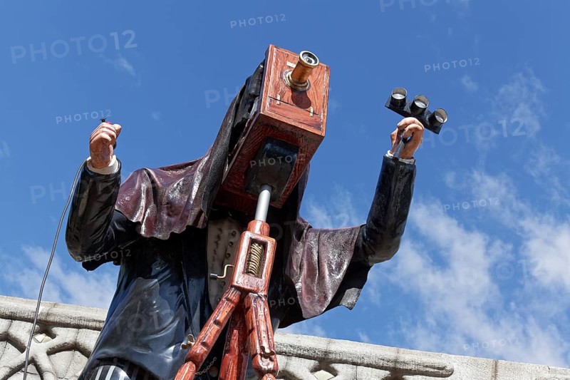 Man taking pictures with a plate camera on a tripod