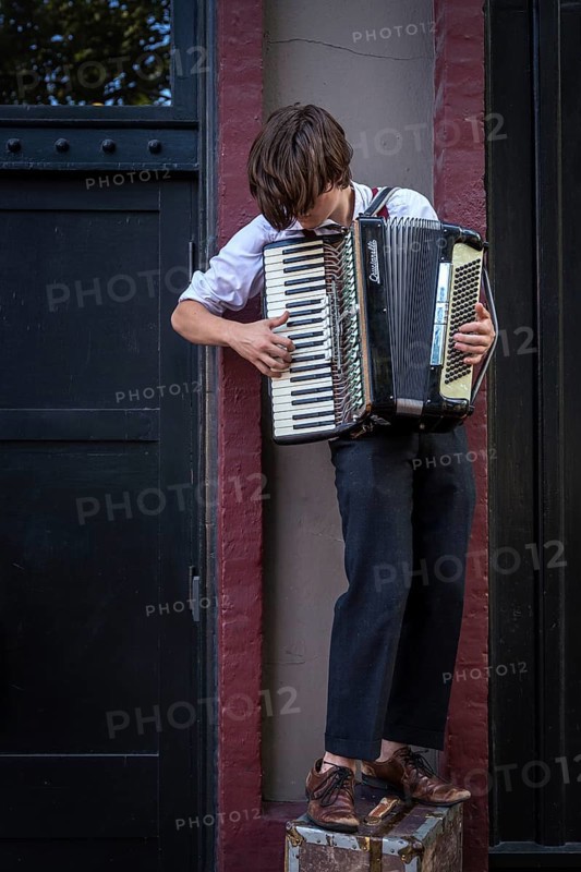 A busker plays an accordion