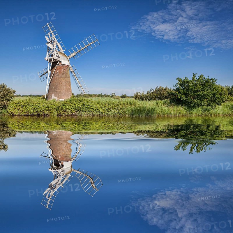 Turf Fen Windmill reflecting in the smooth waters of the Norfolk Broads