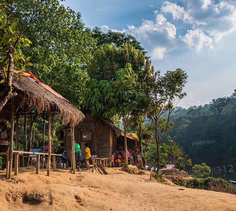 People sitting in front of wooden huts