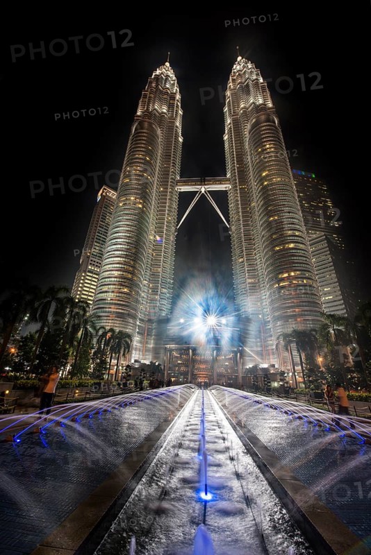 Fountain in front of illuminated Petronas Twin Towers at night