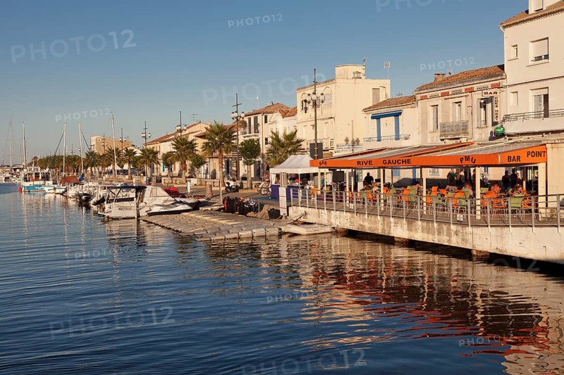 Promenade with restaurants and fishing boats at the harbor