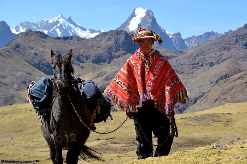 Indio mountain guide with colorful poncho and horse