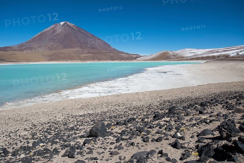 Laguna Verde with deposits of borax on the shore and snow on the mountains