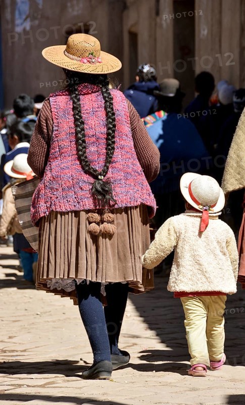 Child holding onto the coattails of its mother