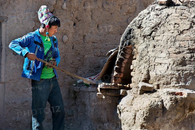 Boy with Chullo preparing breakfast in traditional oven