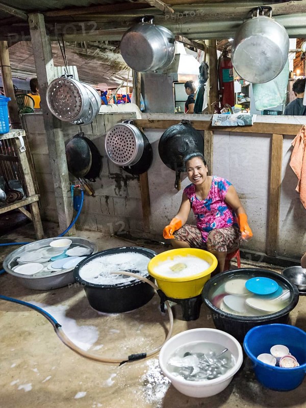 Thai woman washing dishes and pots