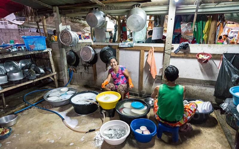 Thai woman washing dishes and pots