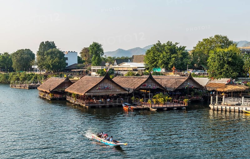 Longtail boat in front of floating houses