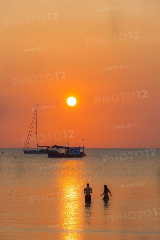 Two people standing in the water