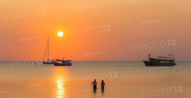 Two people standing in the water