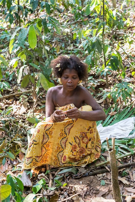 Woman of the Orang Asil tribe sitting in the jungle