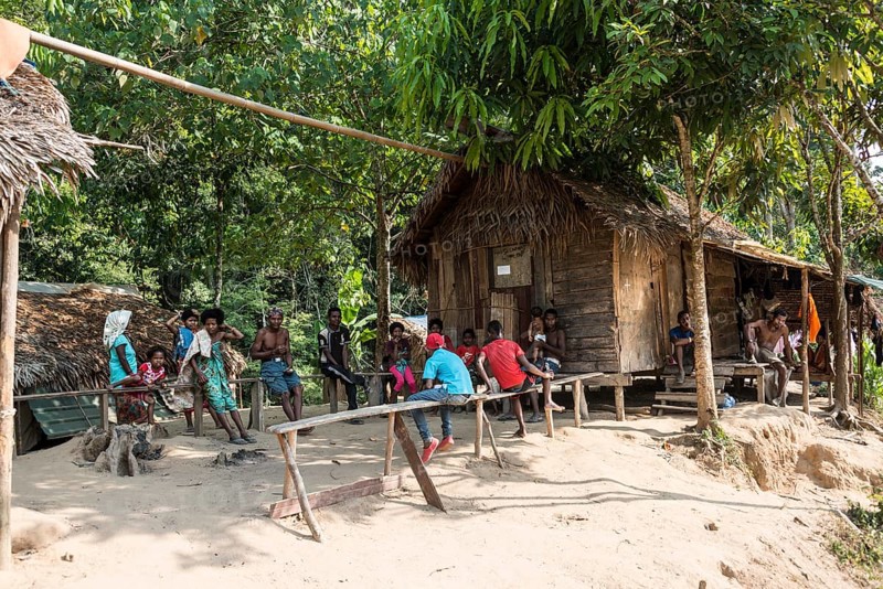 People sitting in front of wooden huts