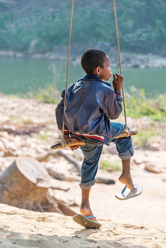 Young Orang Asil boy swinging and looking into the distance