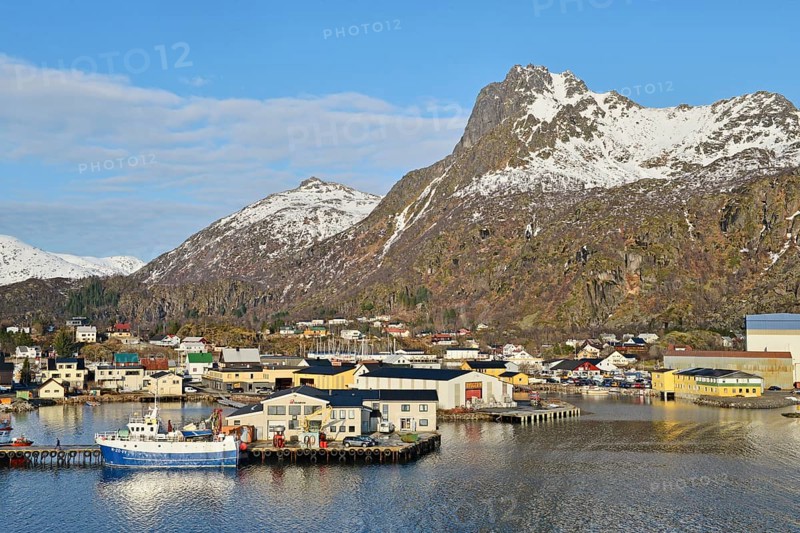 Harbor area with a boat in front of mountain scenery