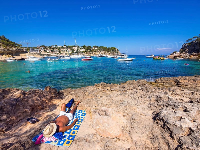 Holidaymaker lying at the bay of Portas Vells