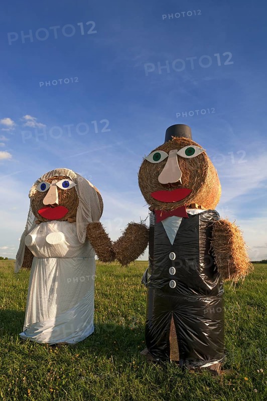 Wedding couple built of straw bales in a meadow