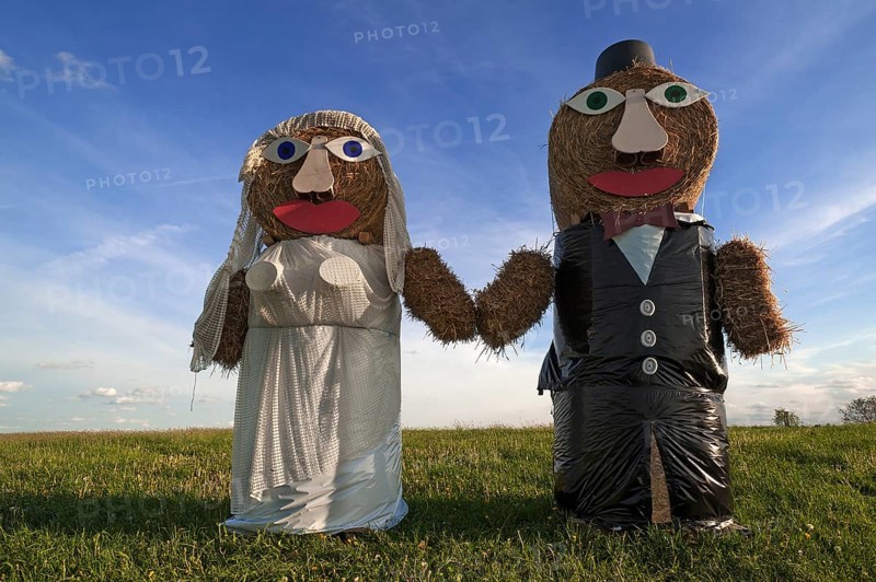 Wedding couple built of straw bales in a meadow