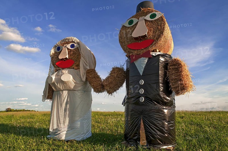 Wedding couple built of straw bales in a meadow