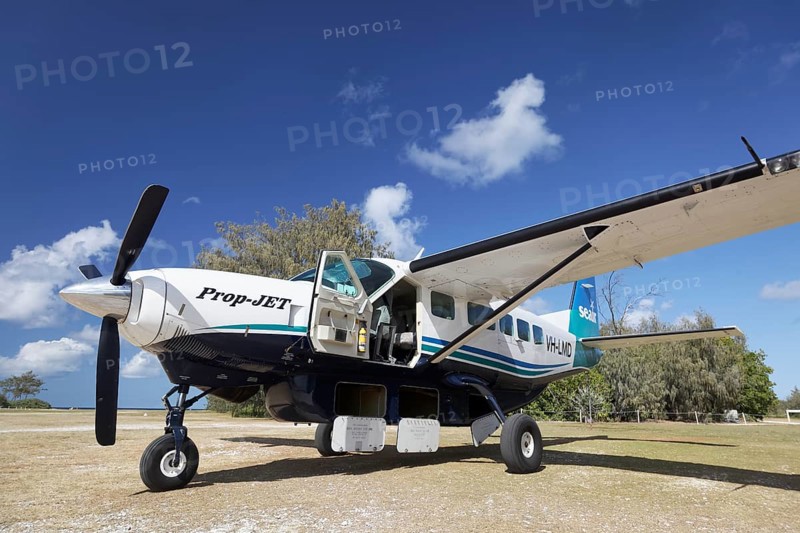 Cessna Caravan 208 Sea Air on unpaved airfield with open underfloor luggage lockers