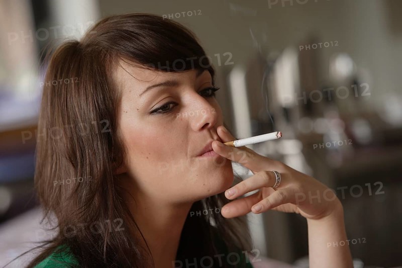 Young woman smoking in a bar or bistro