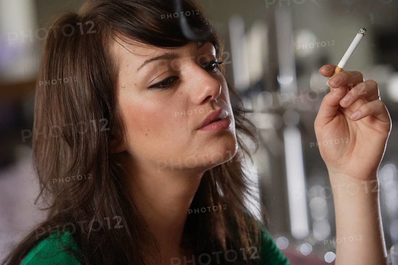 Young woman smoking in a bar or bistro
