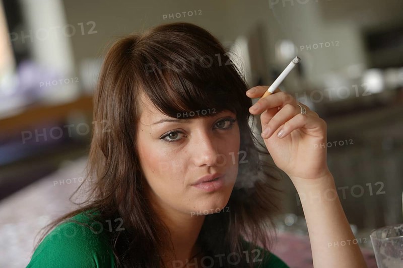 Young woman smoking in a bar or bistro