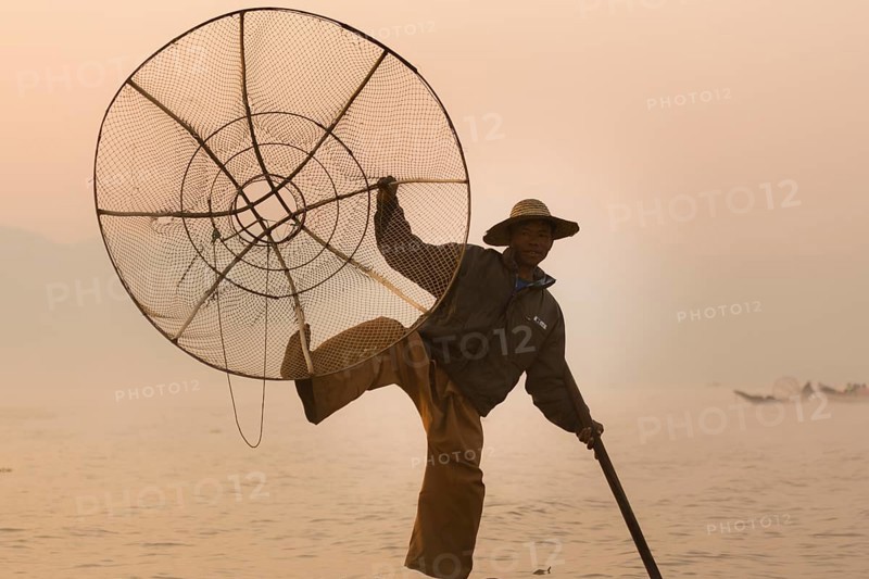 Fishermen rowing with one leg