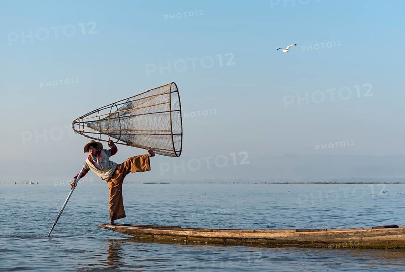 Intha fisherman fishing with traditional conical fishing net