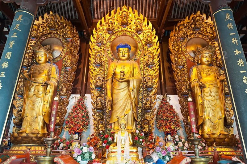 Three golden Buddhas with fire ring