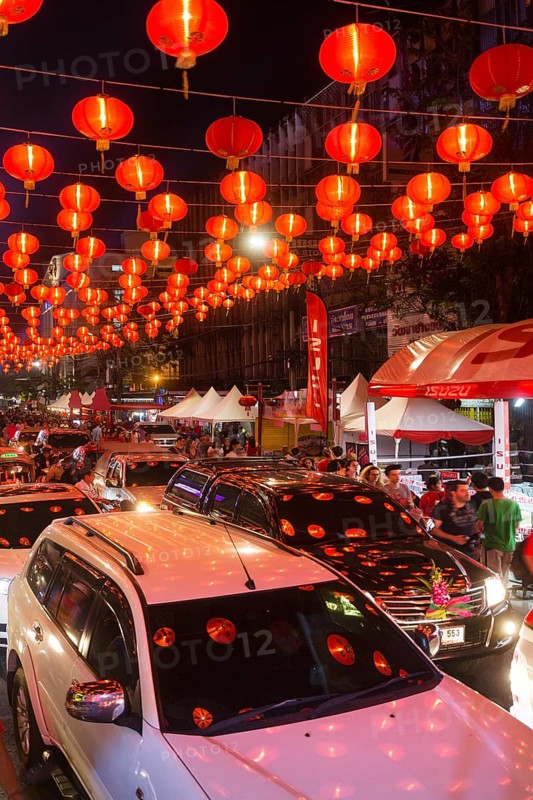 Red chinese lanterns reflecting on cars