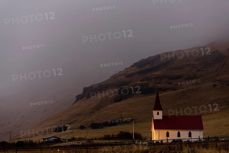 Reyniskirkja church with fog-covered mountains
