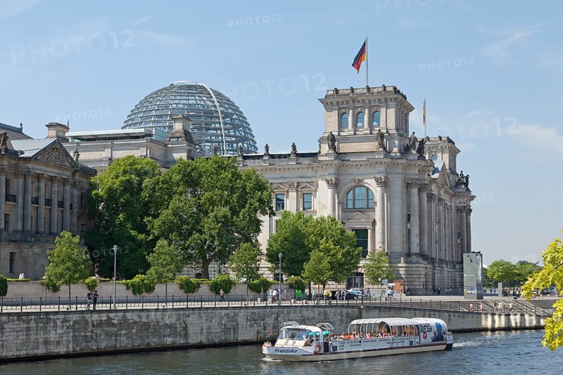 Reichstag parliament with sightseeing boat on the Spree river