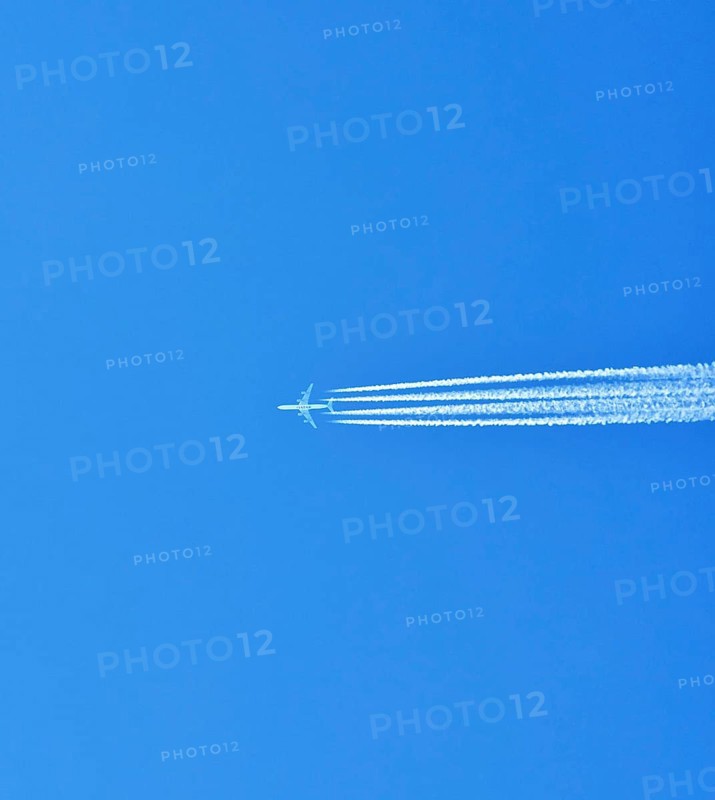 Aibus 380 widebody aircraft of Qatar Airlines with contrails in blue sky