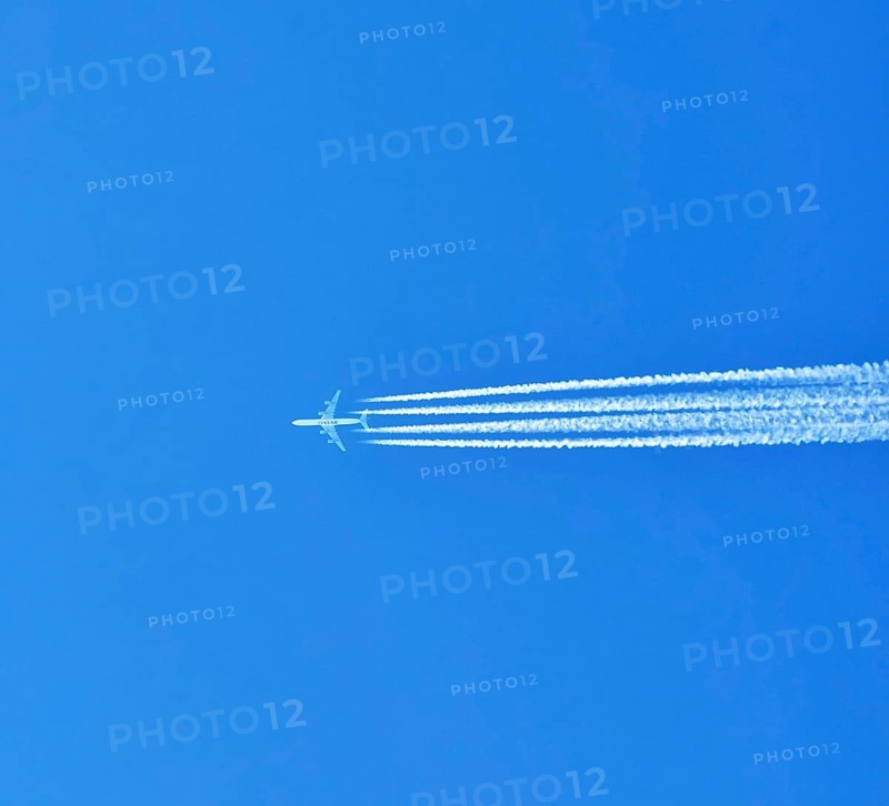 Aibus 380 widebody aircraft of Qatar Airlines with contrails in blue sky