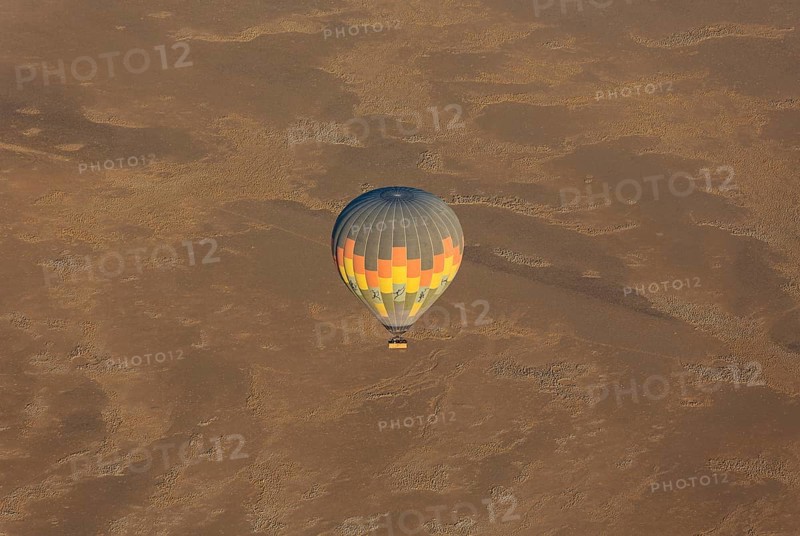 Hot-air balloon above an arid plain at the edge of the Namib Desert