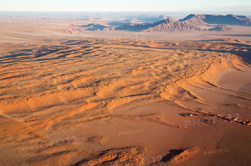 Farmhouse at the foot of a large grass-grown dune at the edge of the Namib Desert
